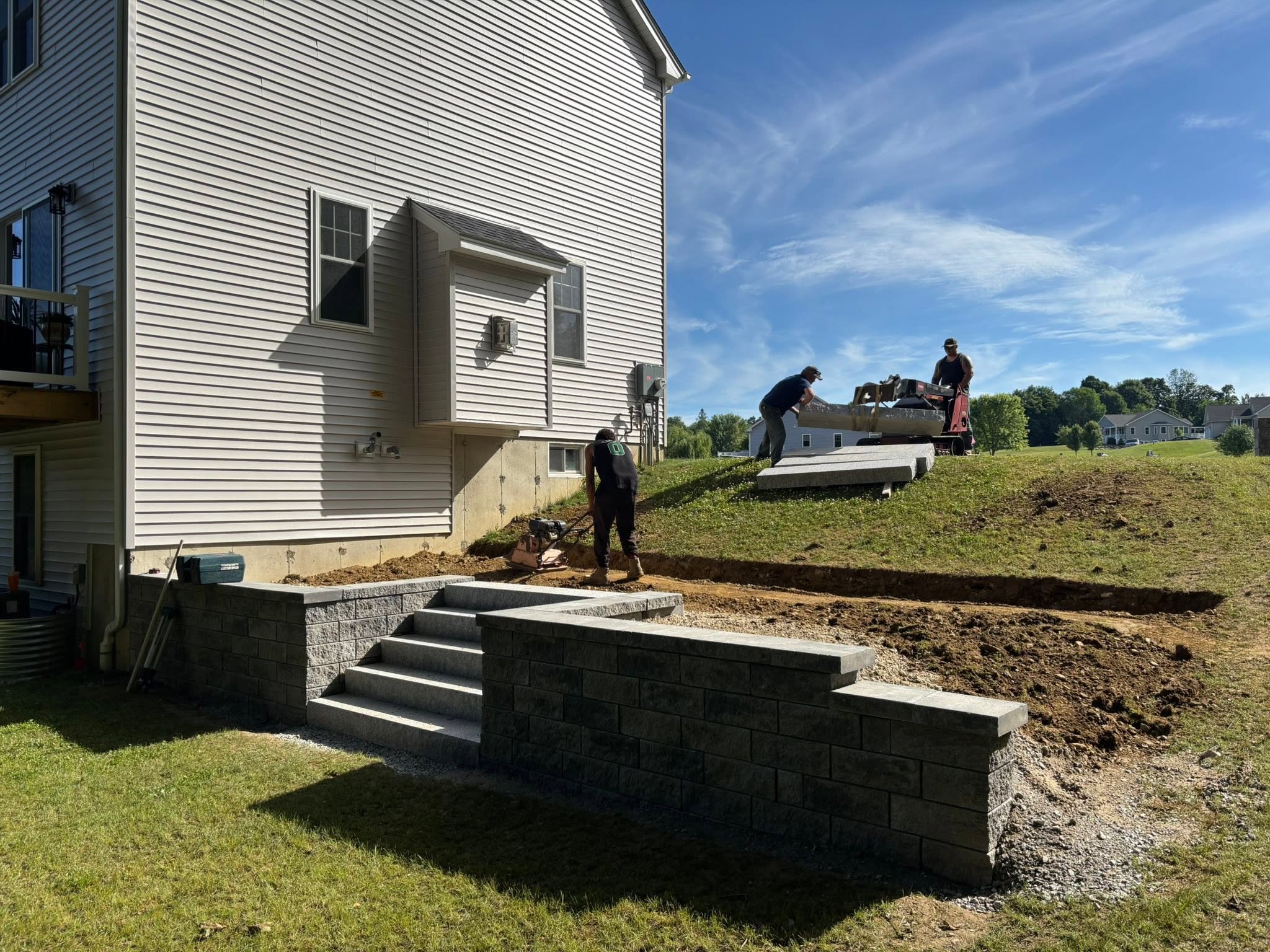 Retaining wall excavation and base preparation in progress